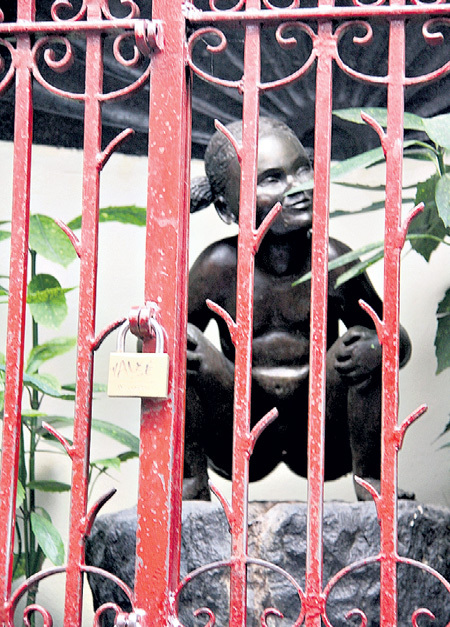 Довольное выражение лица писающей девочки можно разглядеть только через прутья решётки